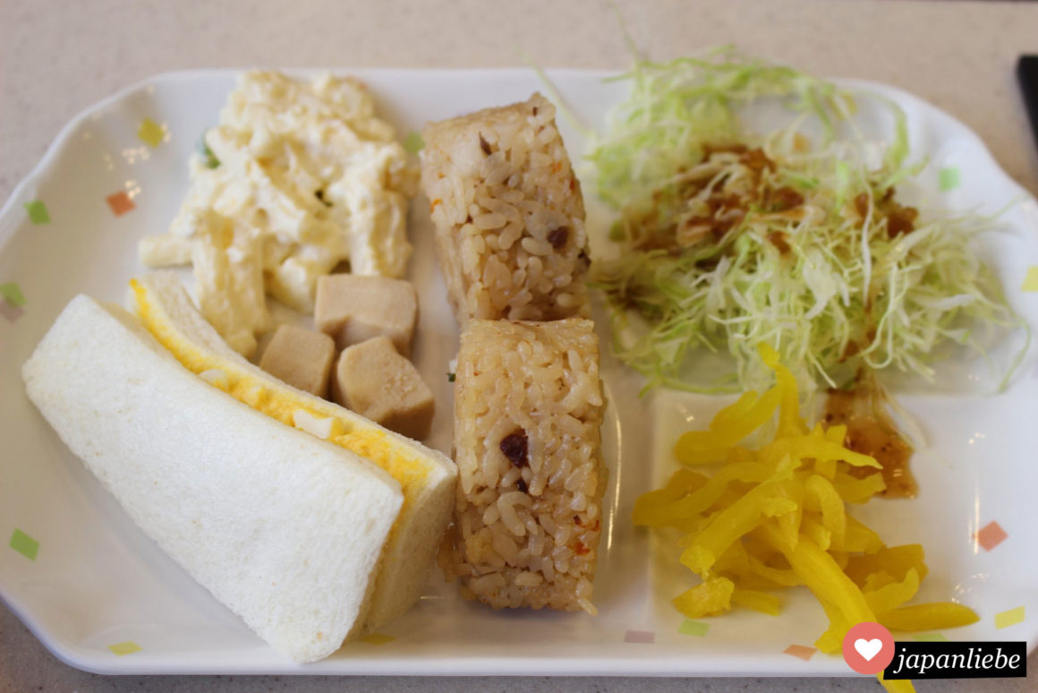 Ein japanisches Frühstück im Toyoko Inn Hotel mit Kartoffelsalat, Reisbällchen und Eiersandwich.
