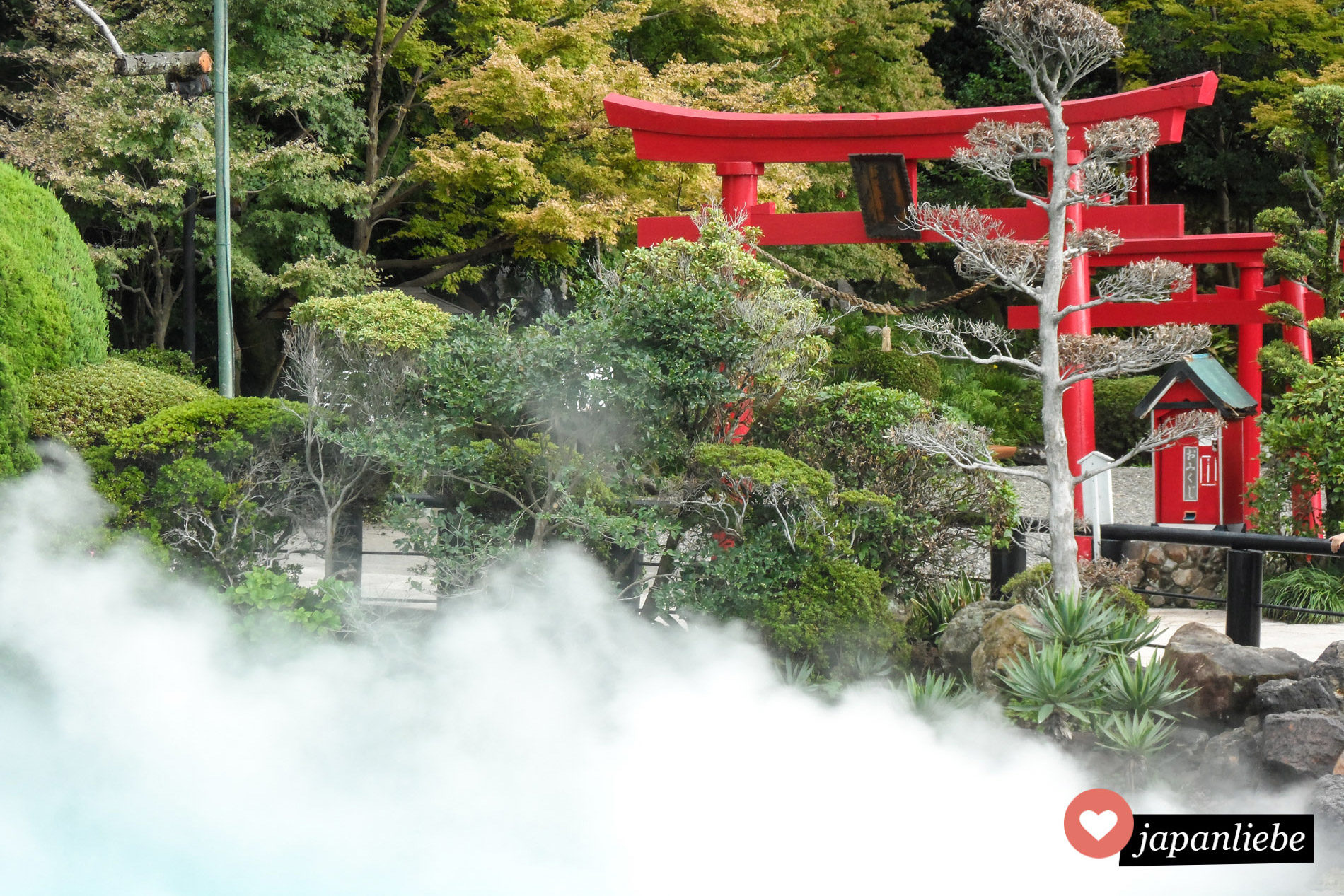 Ein rotes torii hinter den Rauchschwaden in der Meerhölle in Beppu.