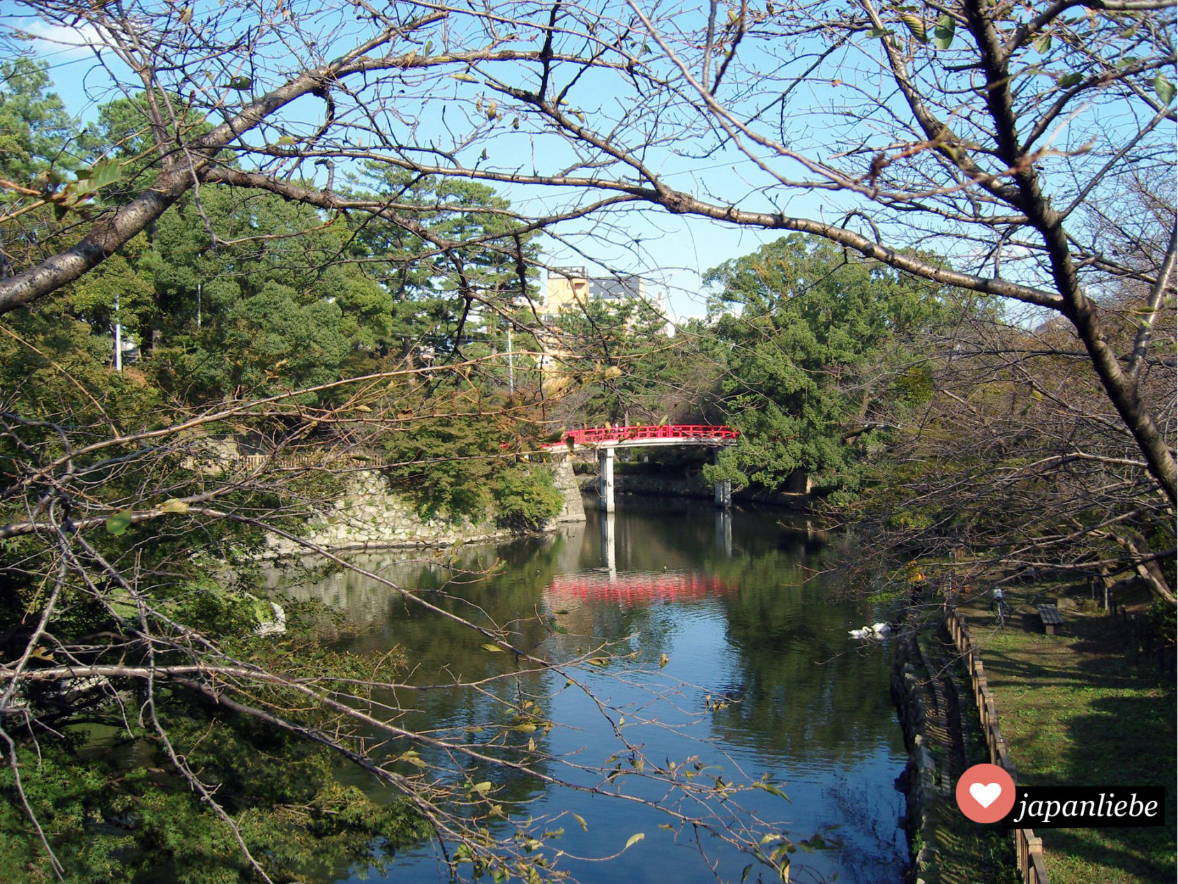 Ein sehr typisch japanischer Anblick: eine rote Brücke spannt sich über den Fluss im Schlosspark von Okazaki.