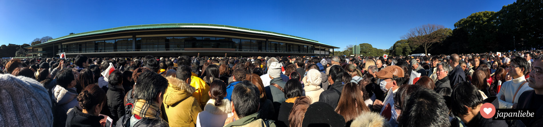 Die Menge wartet – mit Japanflaggen ausgestattet – auf die Neujahrsansprache des japanischen Kaisers.