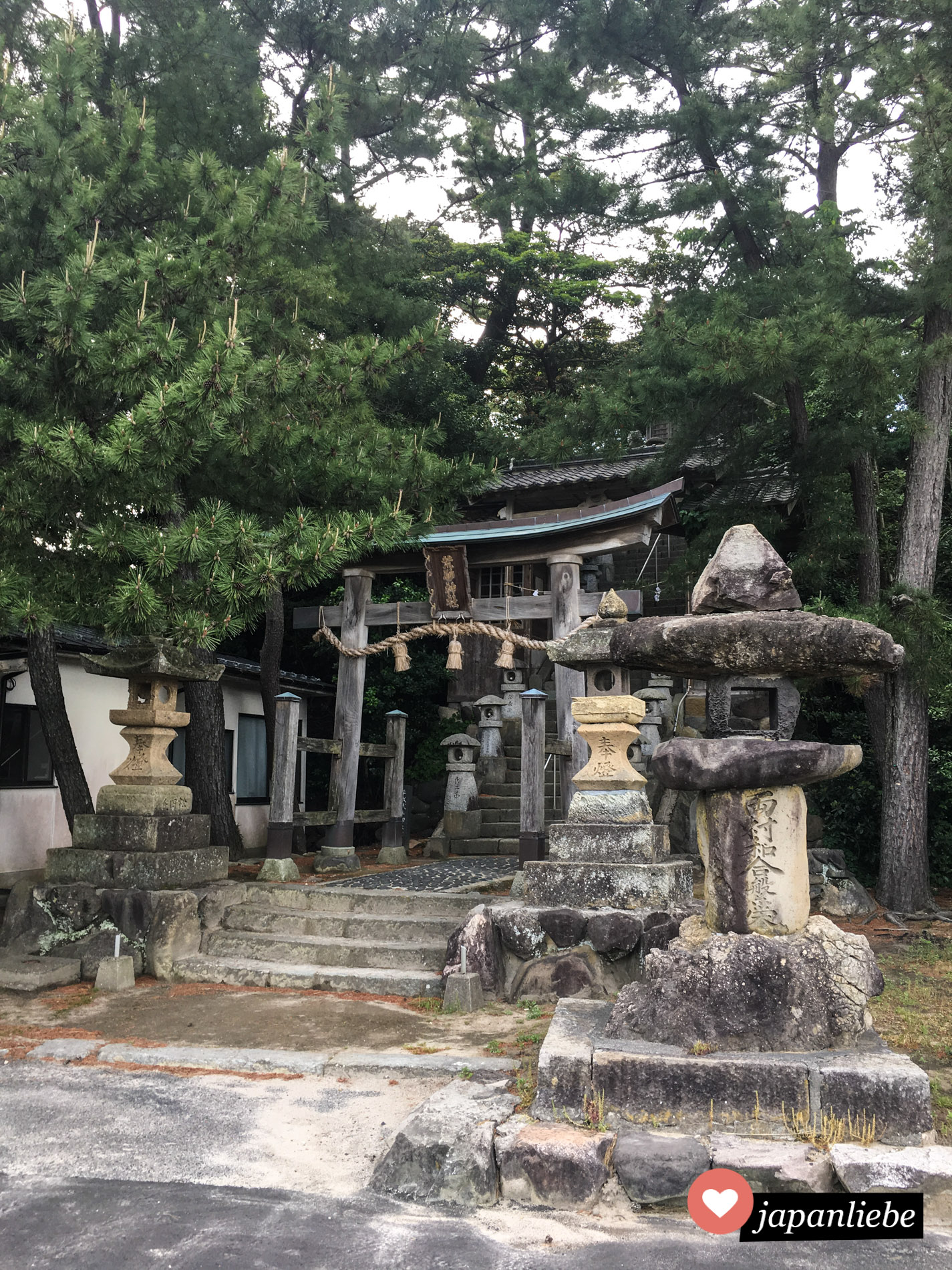 Ein Stein-Torii und Laternen kennzeichnen den Eingang zum Arasuna Schrein in Iwami.