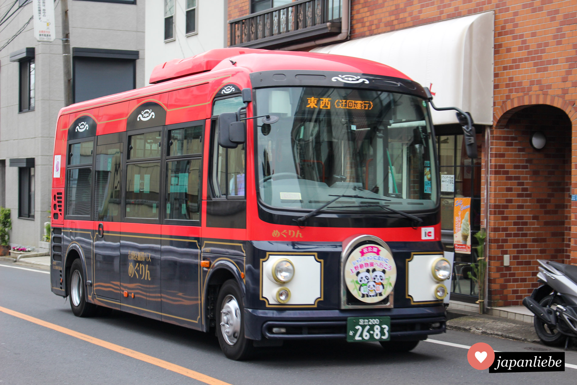 Ein nostalgisch wirkender Bus fährt seine Linie in Tōkyōs Stadtteil Ueno, unverkennbar am Panda auf dem Schild vorne.