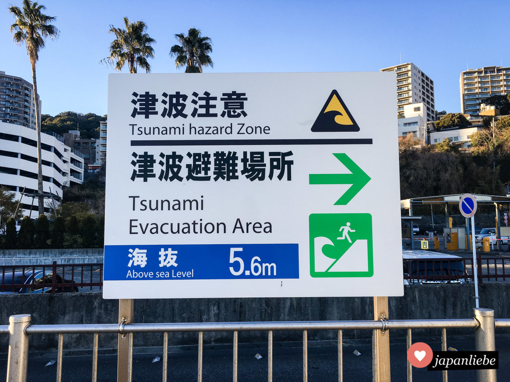 Ein Schild am Strand von Atami zeigt an, wohin man sich im Fall eines Tsunamis begeben sollte.