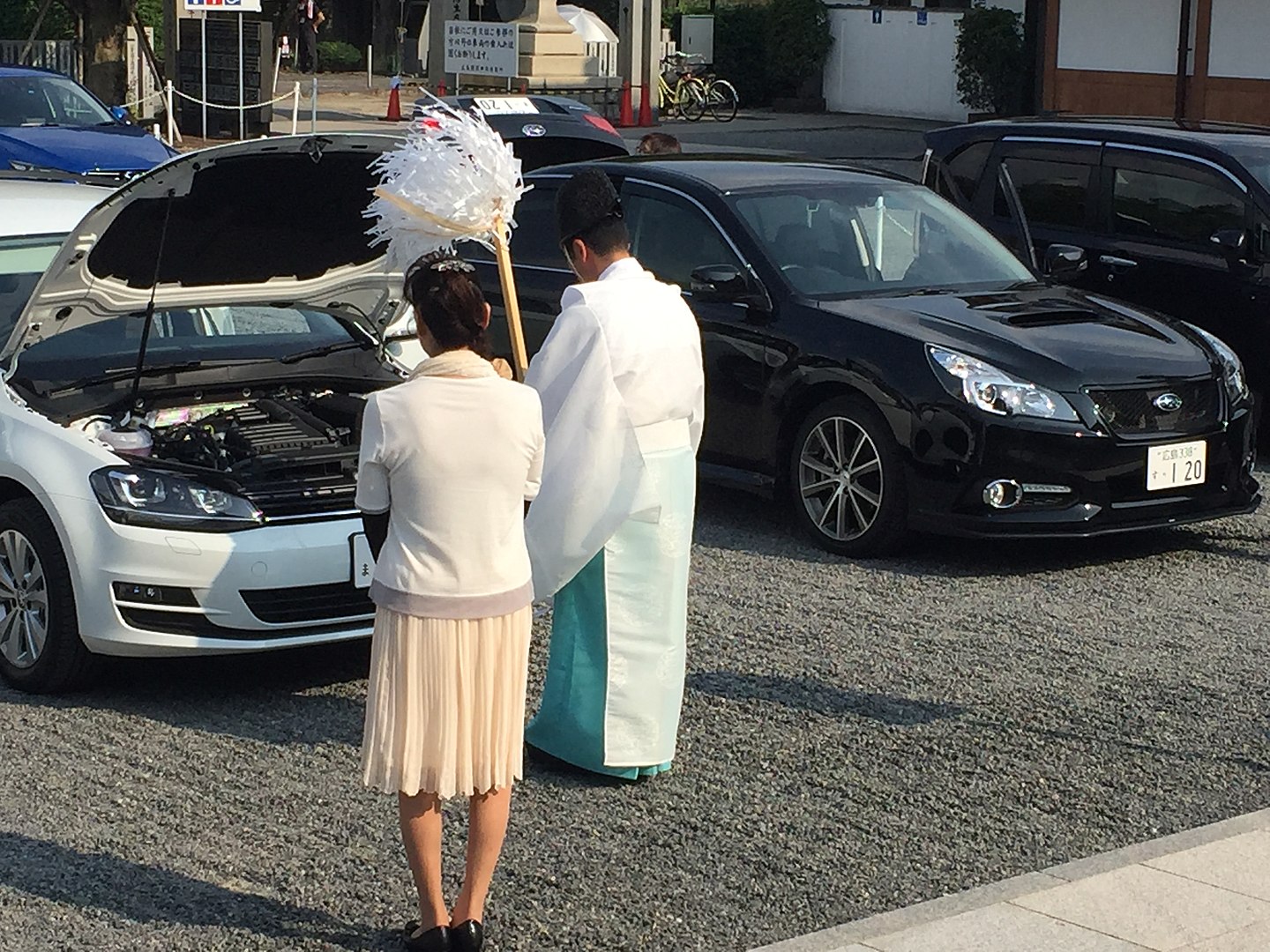 Ein shintō-Priester segnet ein neues Auto. (Foto: malaiya auf Wikipedia https://ja.wikipedia.org/wiki/大麻_(神道)#/media/ファイル:Shinto_Priest_blessing_car.jpg CC BY-SA 4.0)