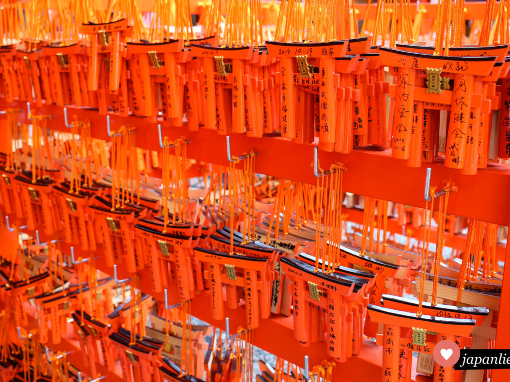 Unzählige rote Tore machen den Fushimi Inari-taisha in Kyōto so einzigartig. Eine kleine Version eines Tors kann man kaufen und mit Wünschen versehen.