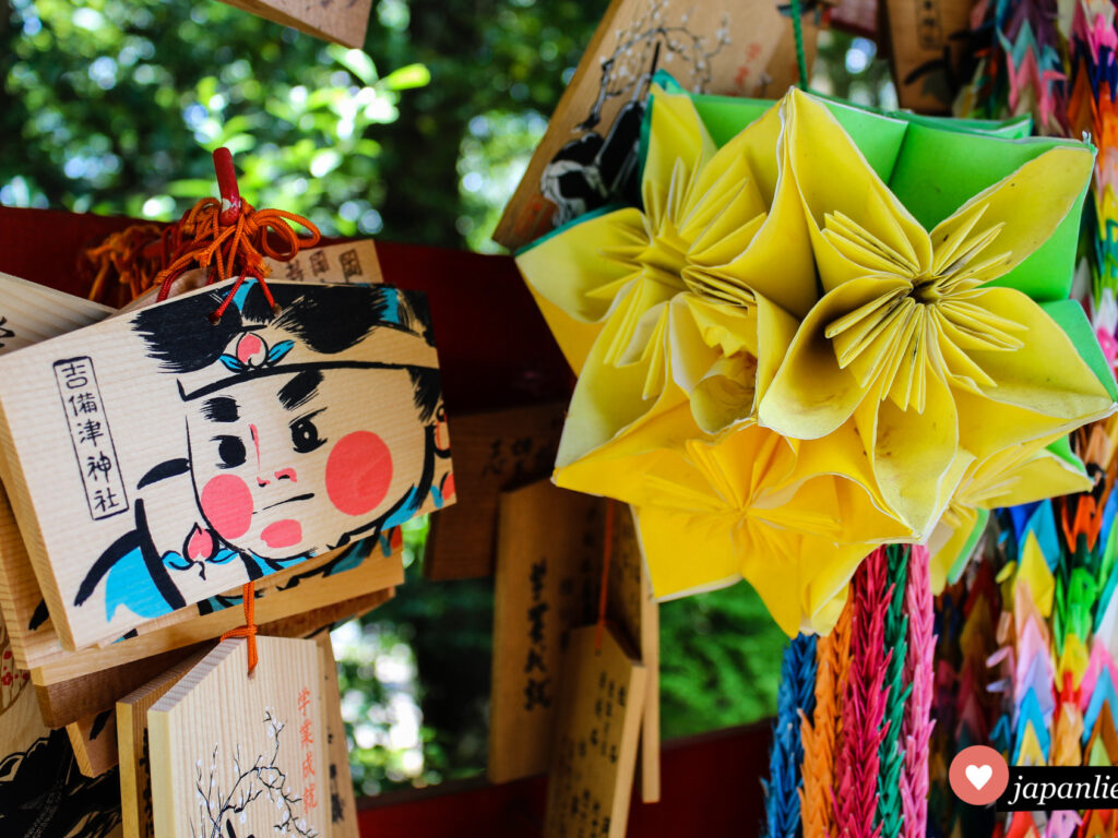 Eine ema-Wunschtafel am Kibistu-Schrein zeigt den Pfirsichjungen Momotarō.