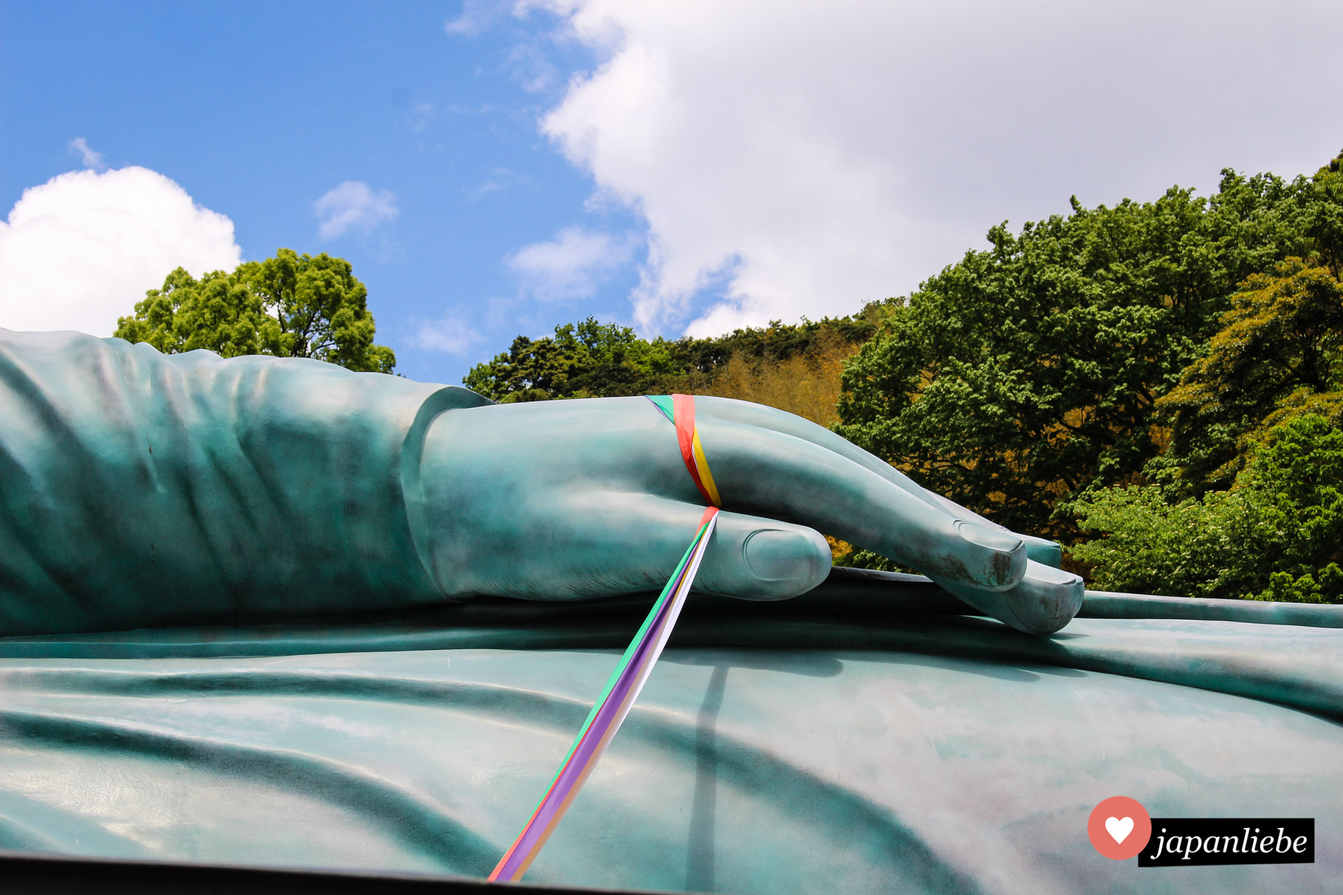 Über die Bänder, die an der Hand des liegenden Buddhas befestigt sind, kann der Besucher direkt in Verbindung mit ihm kommen.