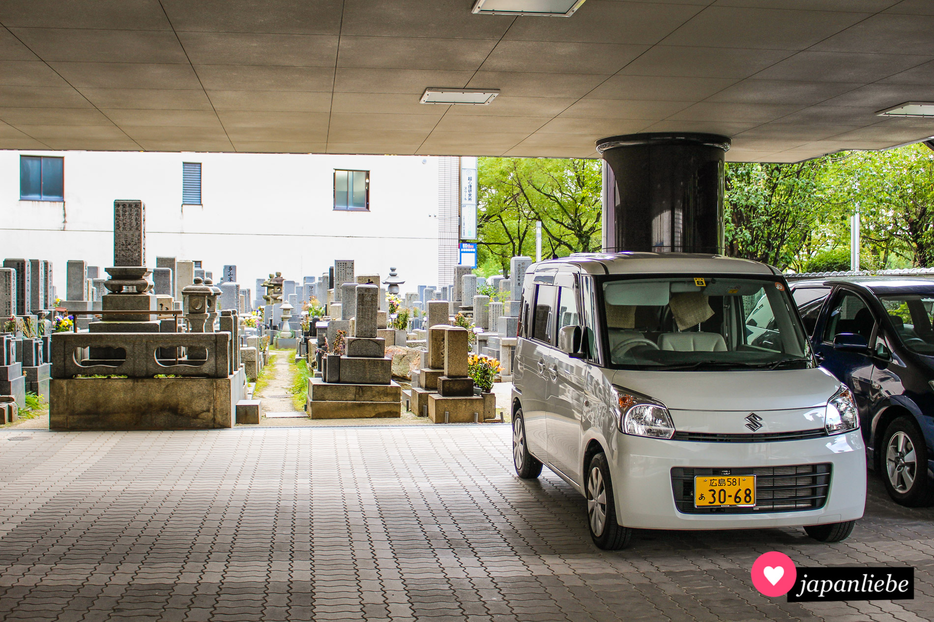 Kein unüblicher Anblick in Japan: ein Friedhof in Hiroshima liegt direkt neben dem Parkplatz eines Wohnhauses.
