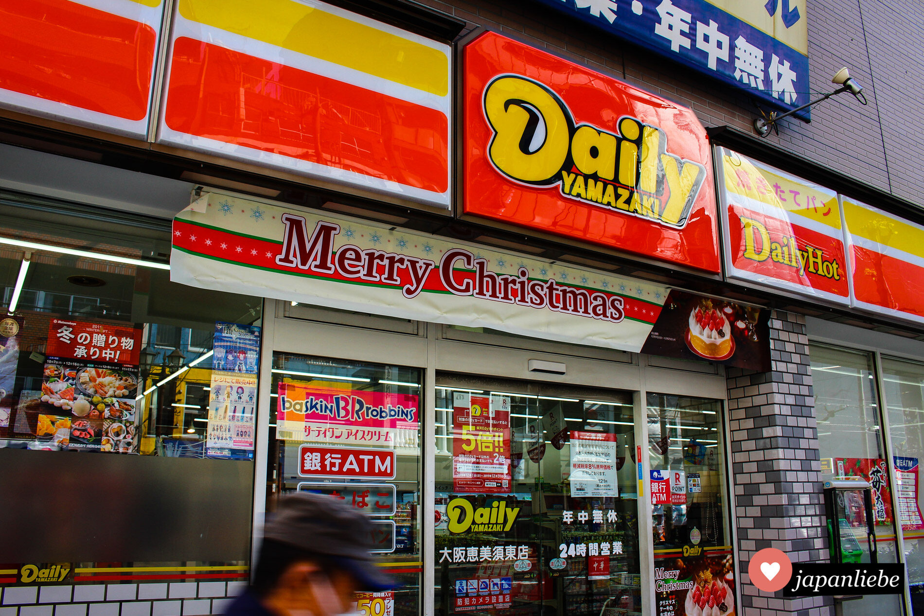 Ein Convenience Store bewirbt seine Weihnachtstorten mit einem "Merry Christmas"-Banner.