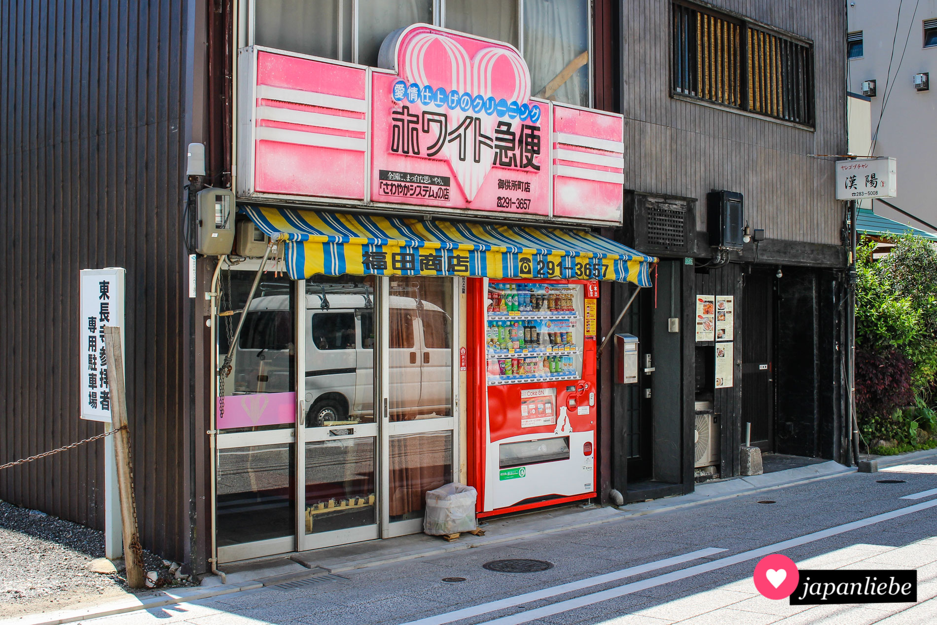 Platz für einen Getränkeautomaten ist in der kleinsten Nische, so wie hier an der Fassade einer Reinigung in Fukuoka.