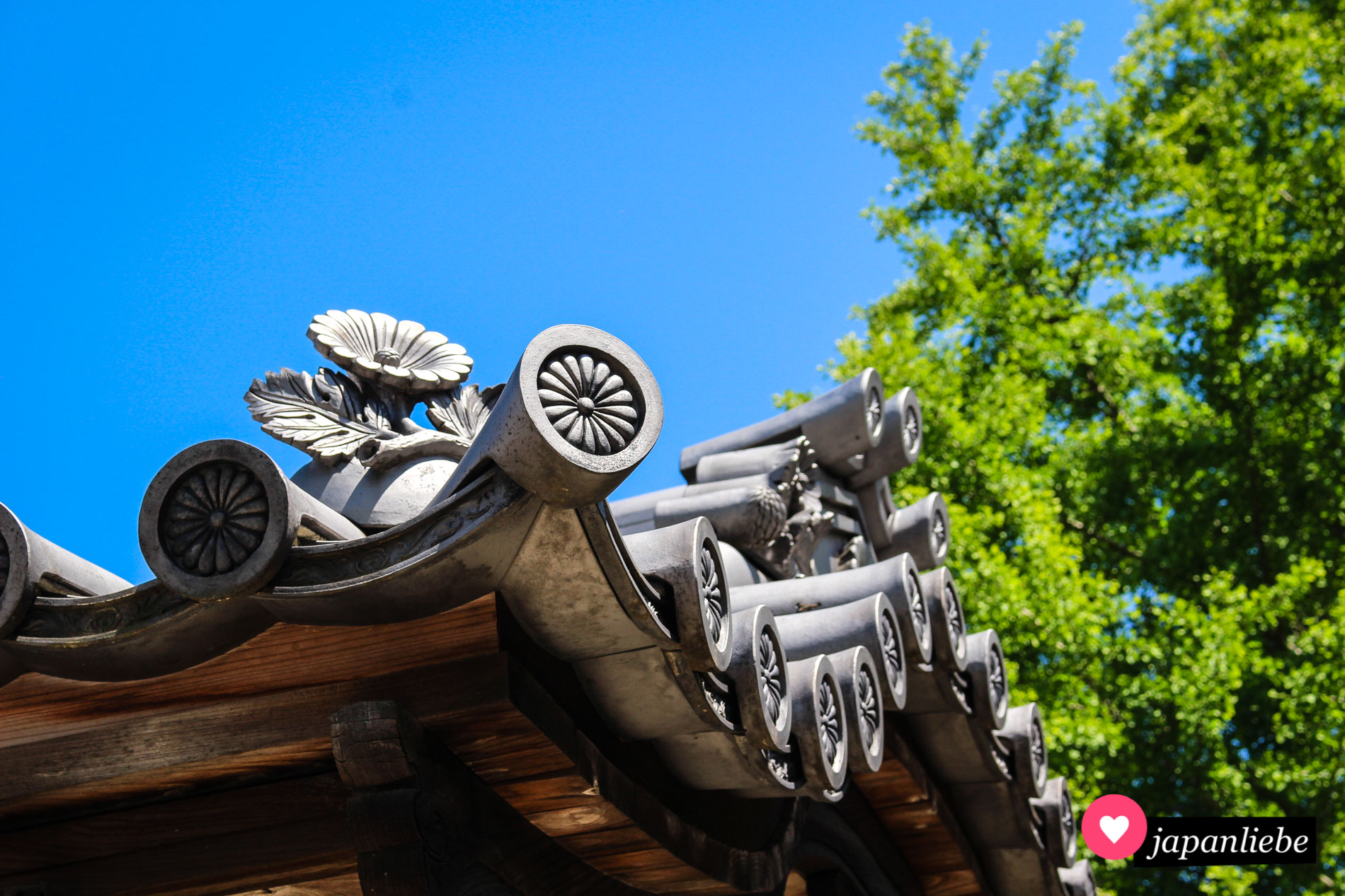 Sowohl onigawara als auch gatō-Ziegel auf diesem typisch japanischen Dach in Fukuoka zeigen Blumen.