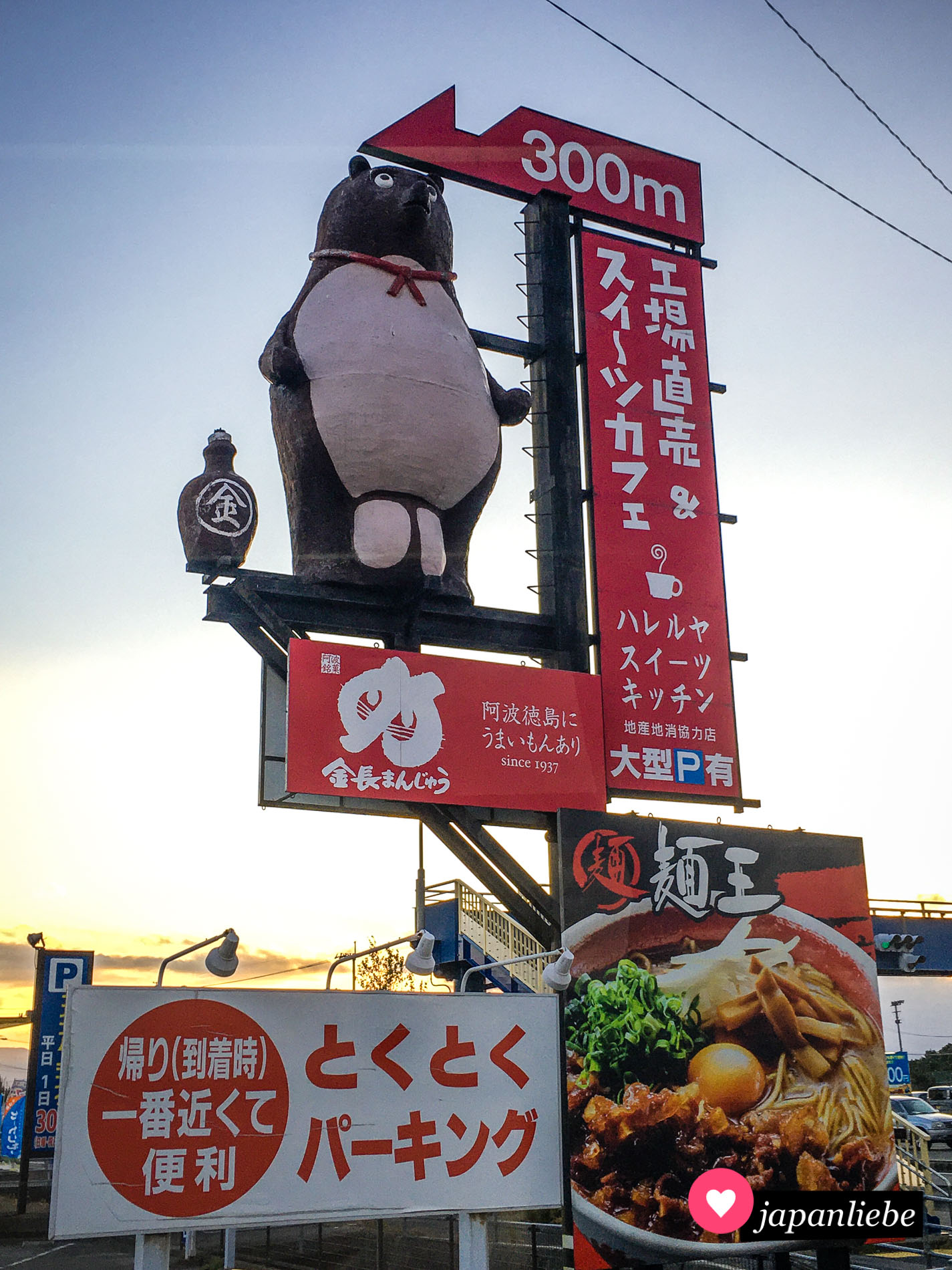 Ein Wegweiser zu einem Restaurant auf Shikoku mit riesiger Tanuki-Figur.
