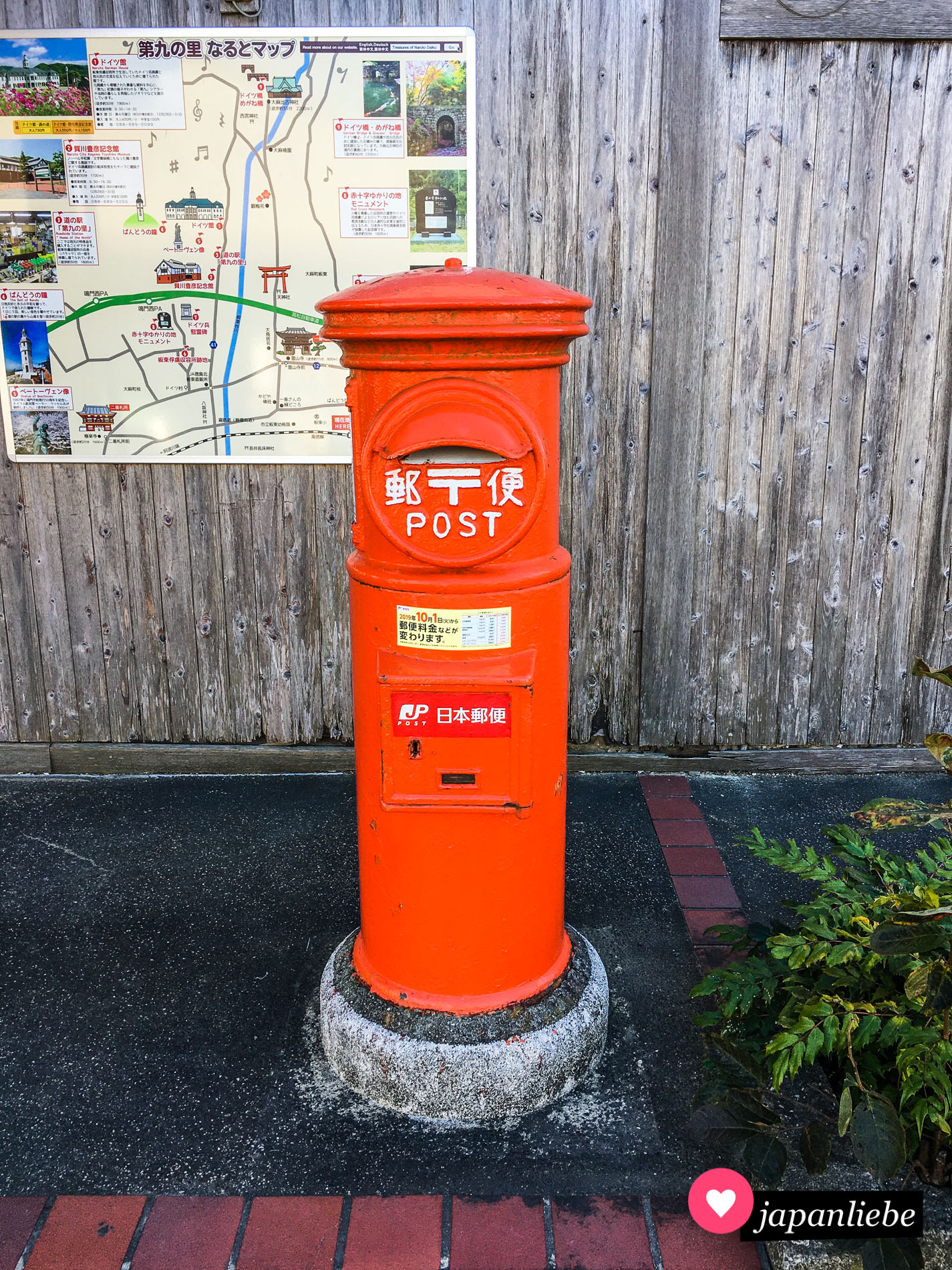 Ein klassisch, japanischer Briefkasten in rot und rund am Bahnhof von Bandō.