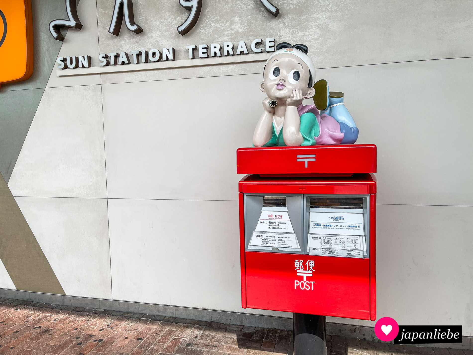Am Bahnhof von Okayama ziert die Märchenfigur Momotarō einen Briefkasten.