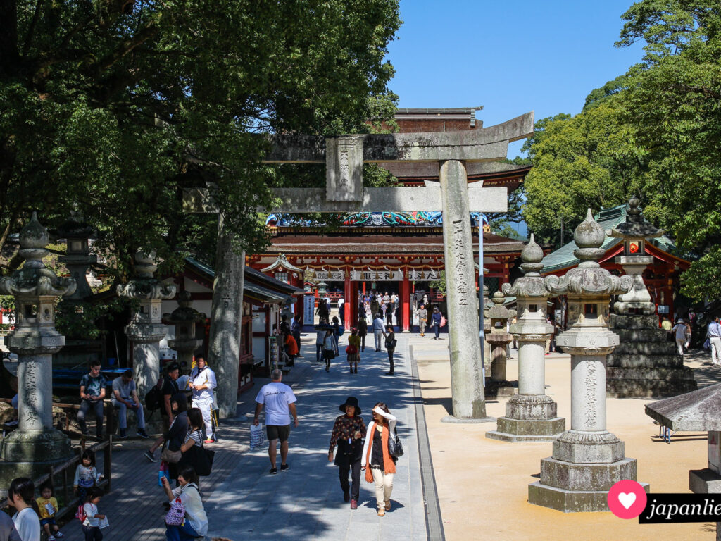 Ein steinernes torii und Laternen säumen den Weg zum Dazaifu Tenman-gū-Schrein.