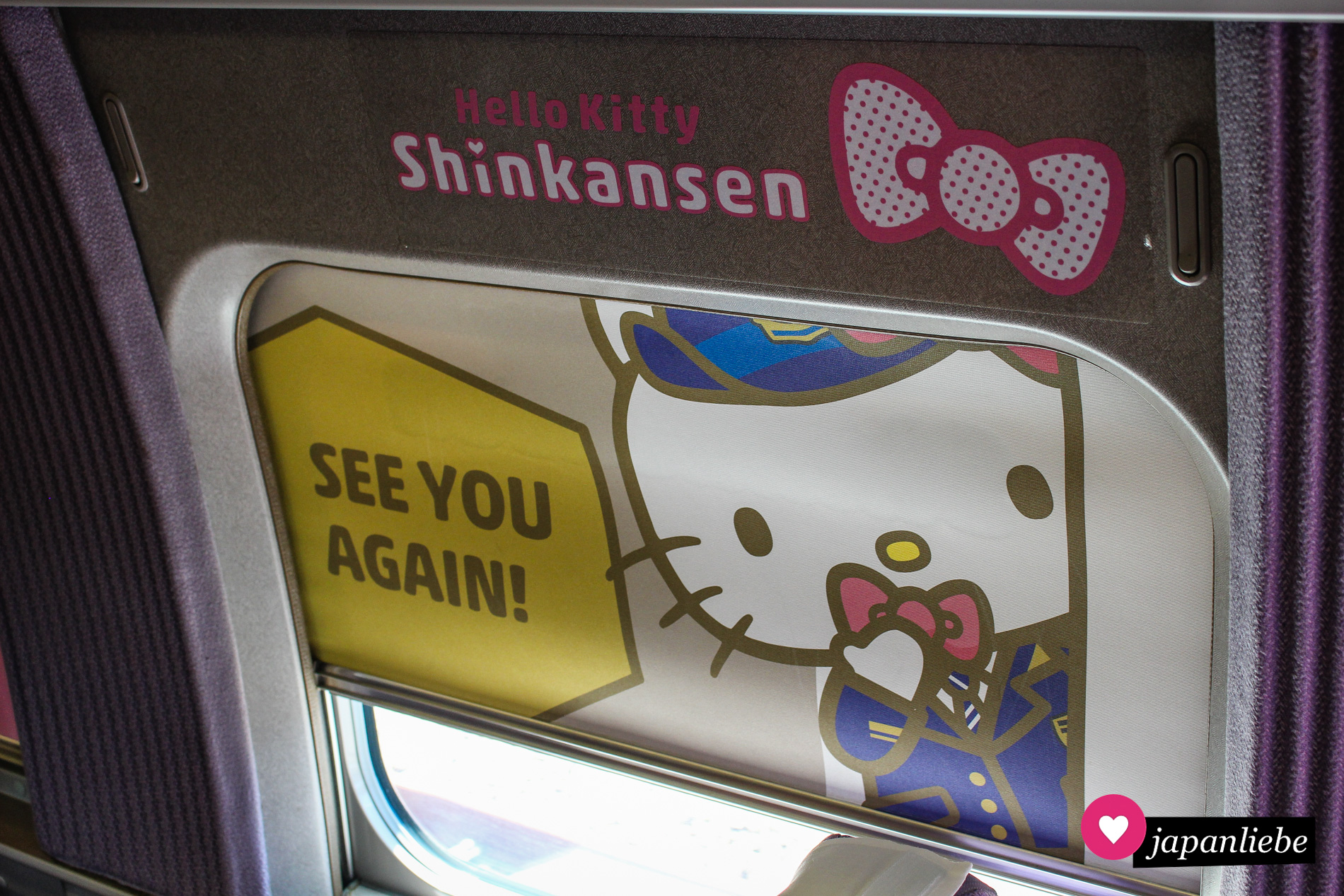 Eine Sonnenblende fordert dazu auf, den Hello-Kitty-Shinkansen bald wieder zu verwenden.