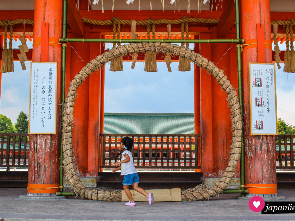 Ein Mädchen läuft am „chinowa“-Ring des Heian-jingū-Schreins in Kyōto vorbei.