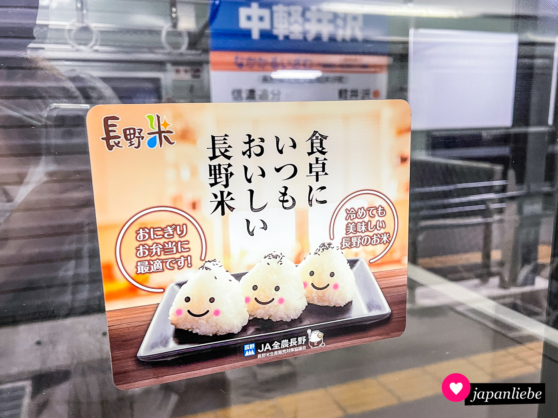 Ein Werbeaufkleber in der U-Bahn zeigt drei Reisbällchen mit lächelnden Gesichtern.