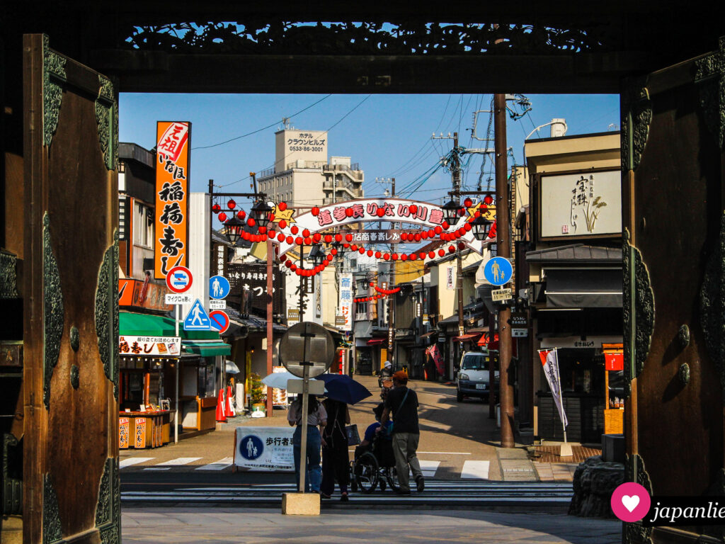Blick durchs Tor des Toyokawa Inari-Tempels auf die Omotesandō-Einkaufsstraße.