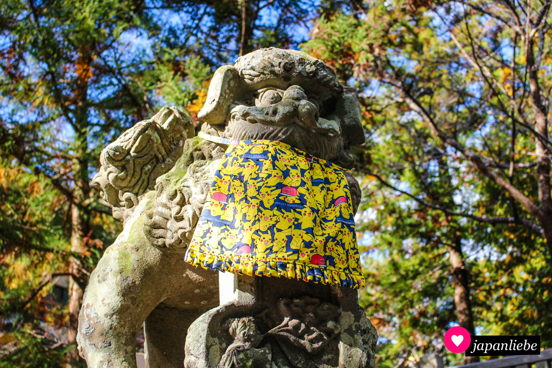 Überschneidung der Religionen und Kulturen bei diesem „komainu“-Löwenhund, der ein Pikachu-Lätzchen trägt.