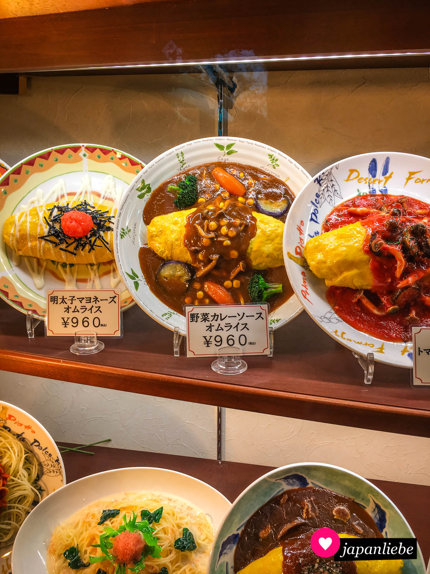 Japanisches Omuraisu-Omelette mit diversen Soßen und Toppings. Unter anderem Rogen, Curry und Tomaten.