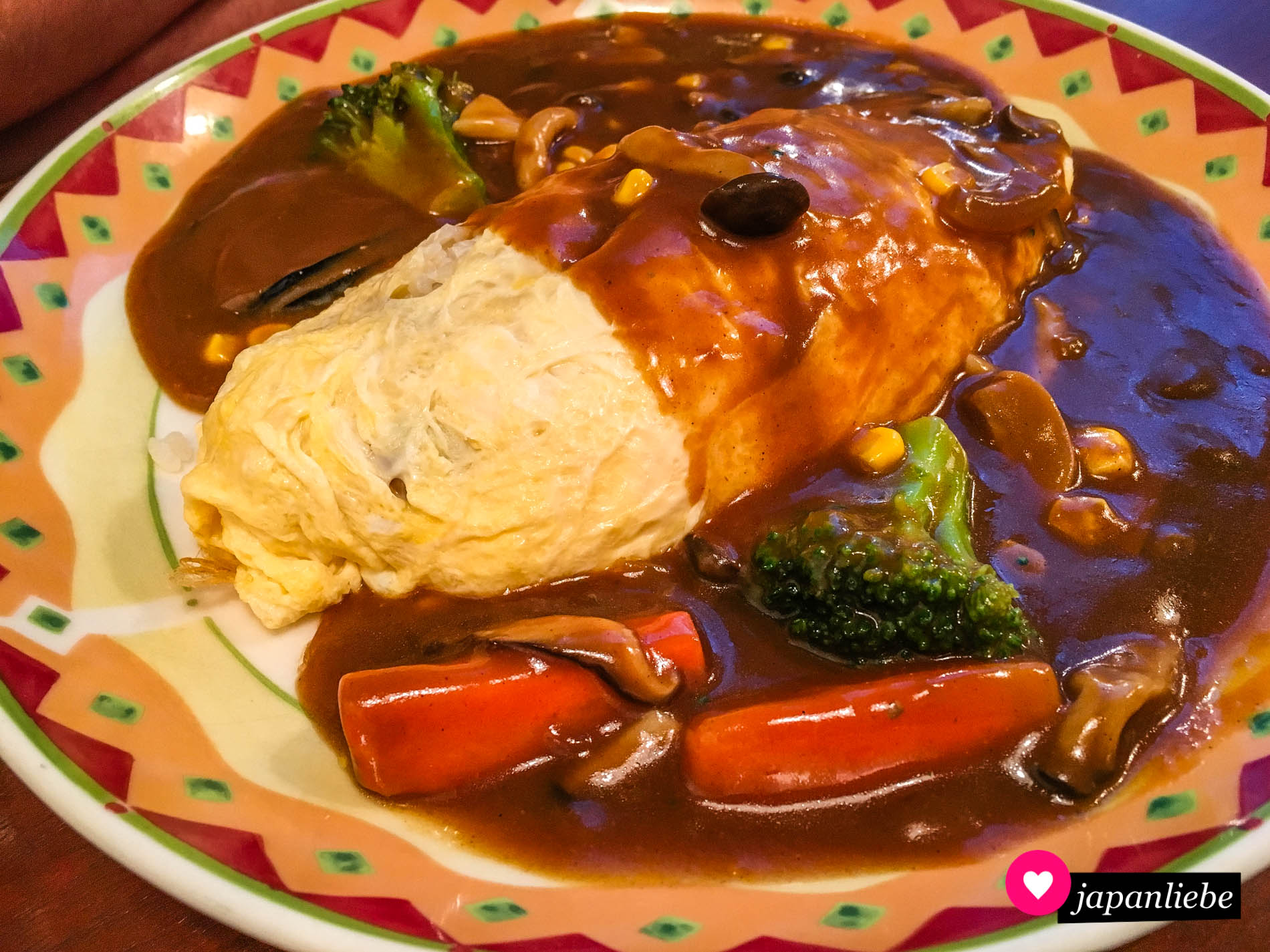 Ein japanisches Omuraisu-Omelette mit Demi-Glace-Soße, Pilzen und Gemüse.
