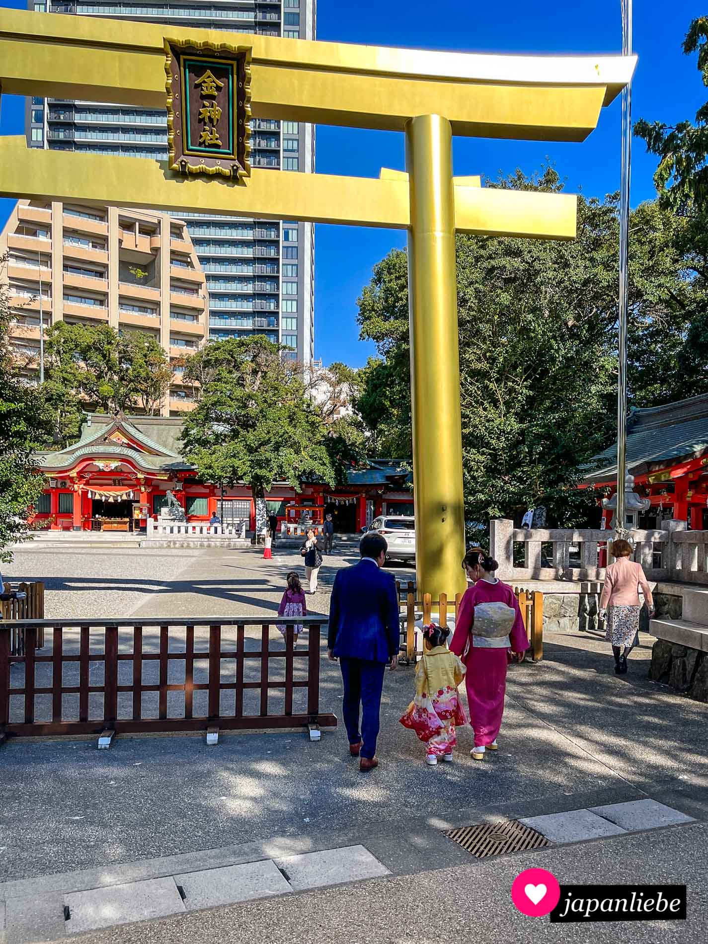 Das goldene Torii des Kogane-Schreins in Gifu und ein Familie, die zum shichi-go-san-Fest herausgeputzt ist.