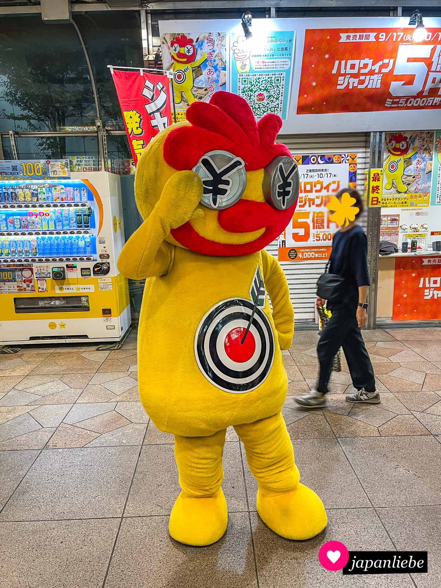 Ein schon etwas in die Jahre gekommenes Maskottchen soll Passanten am Bahnhof in Nagoya dazu animieren, Lotto zu spielen.