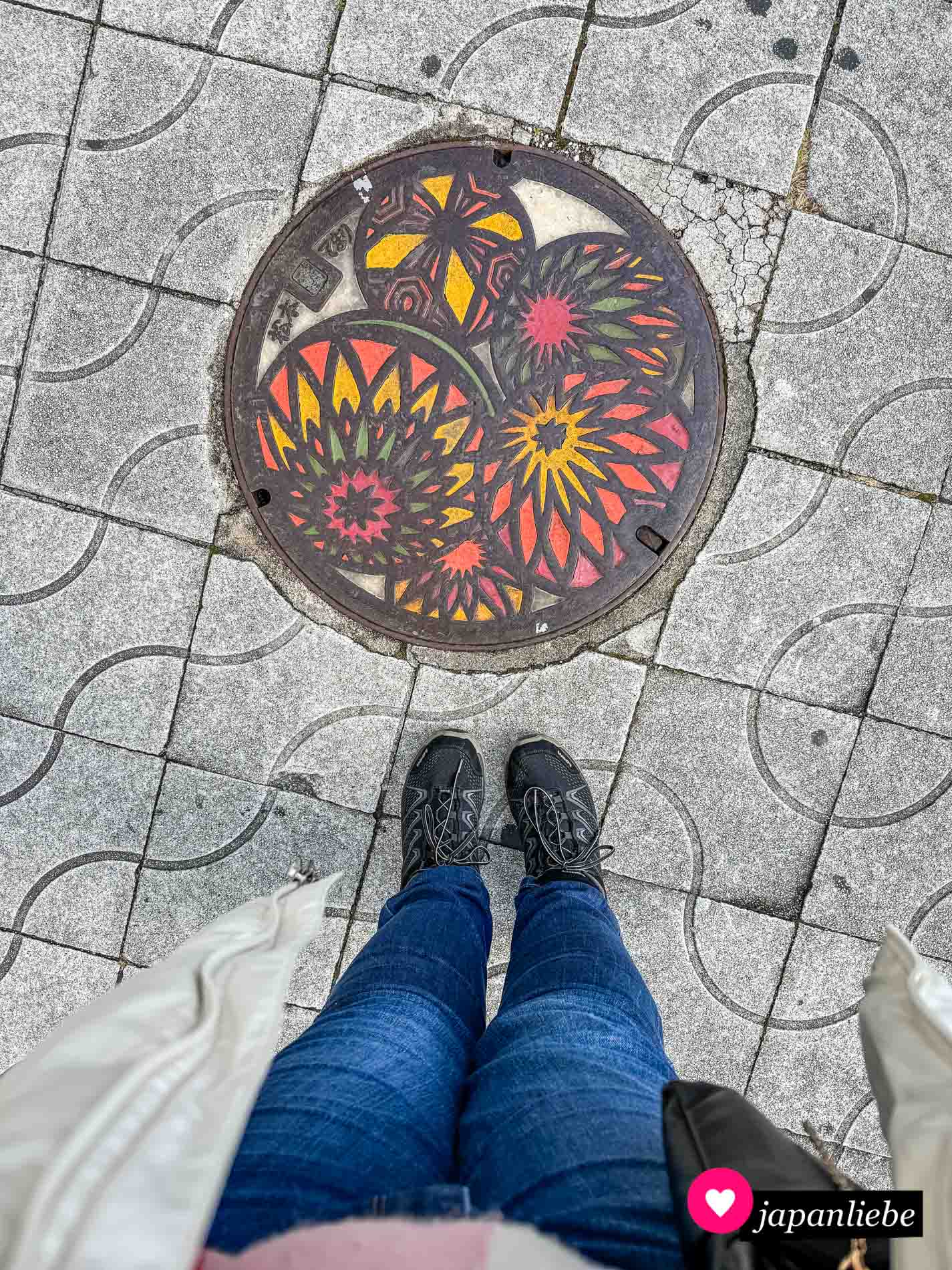 Einer der vielen bunten Kanaldeckel von Matsumoto, der „temari“-Bälle zeigt.
